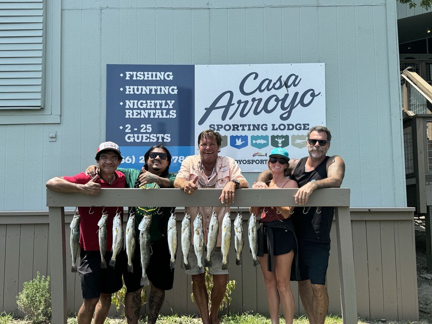 Guests with a rack of redfish under the Casa Arroyo sign