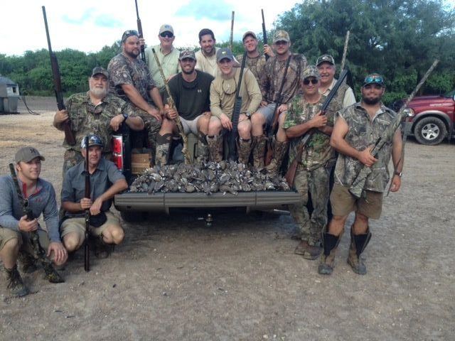 A large dove hunting party with the day's birds on the trailer