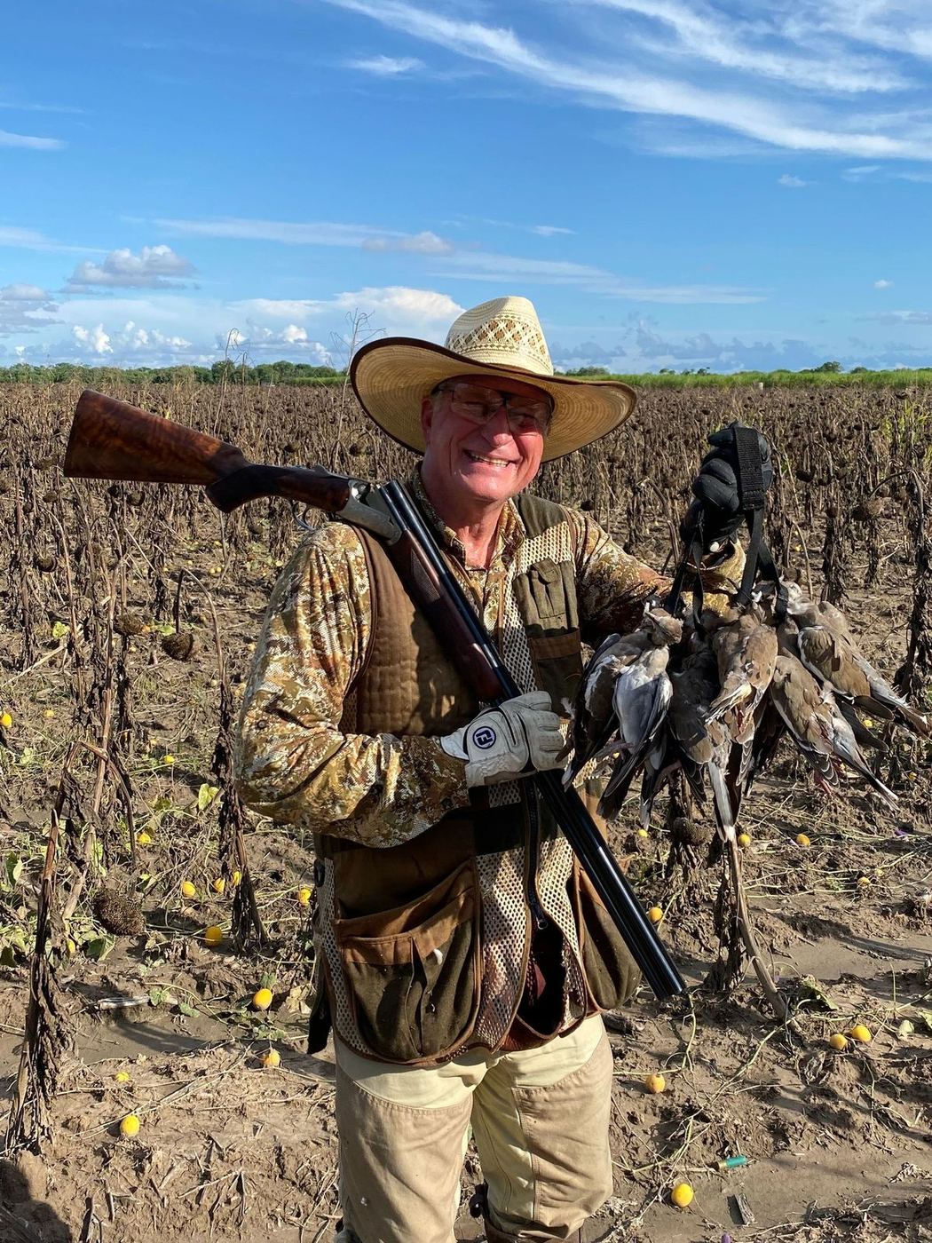 Hunter with white-winged dove in a harvested sunflower field
