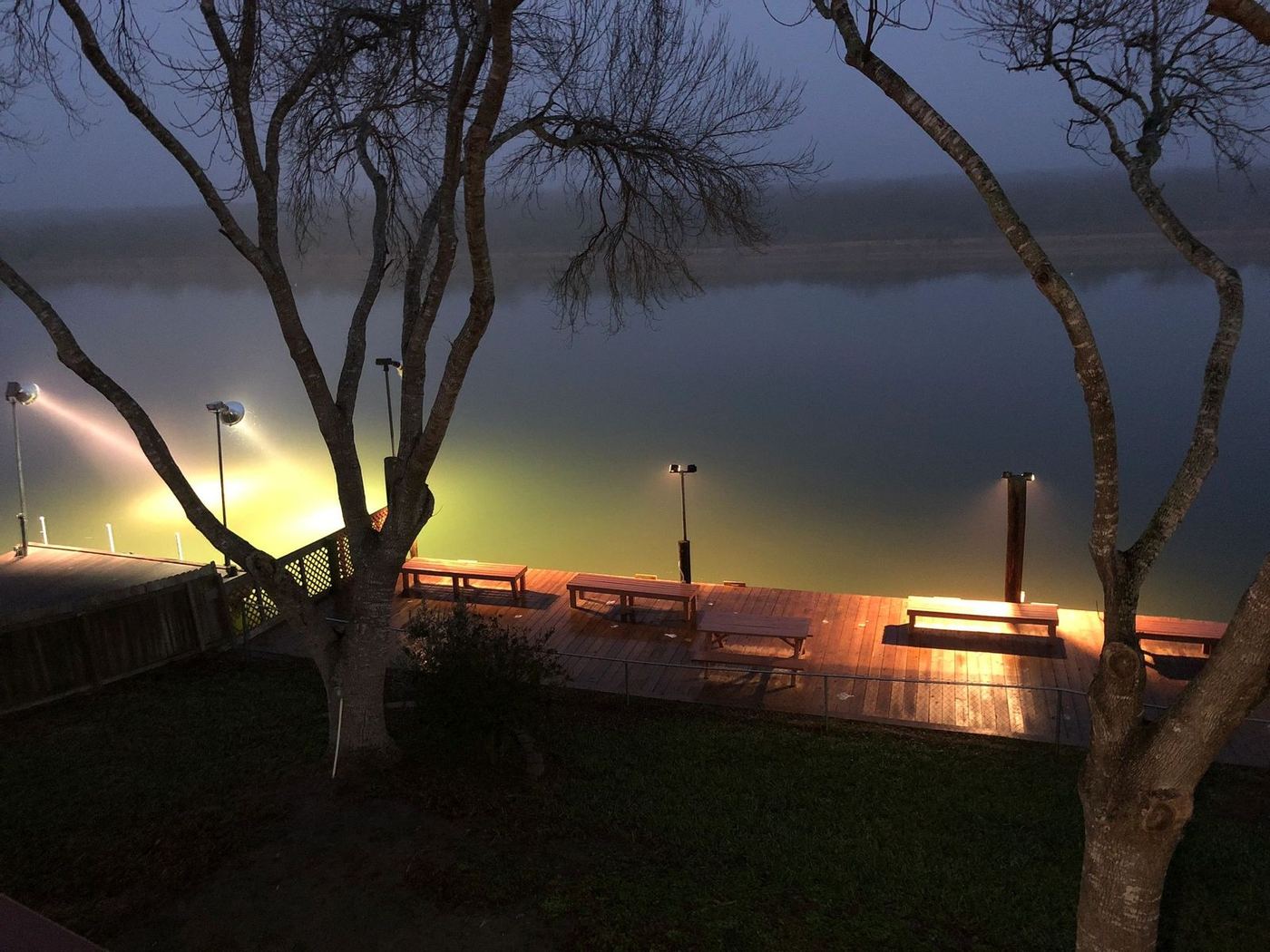 The lighted pier and shoreline at dusk