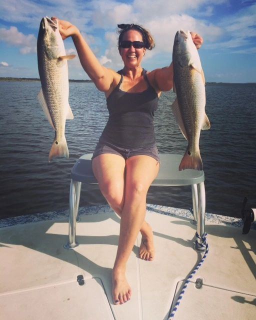 Angler with a pair of speckled trout on the front deck